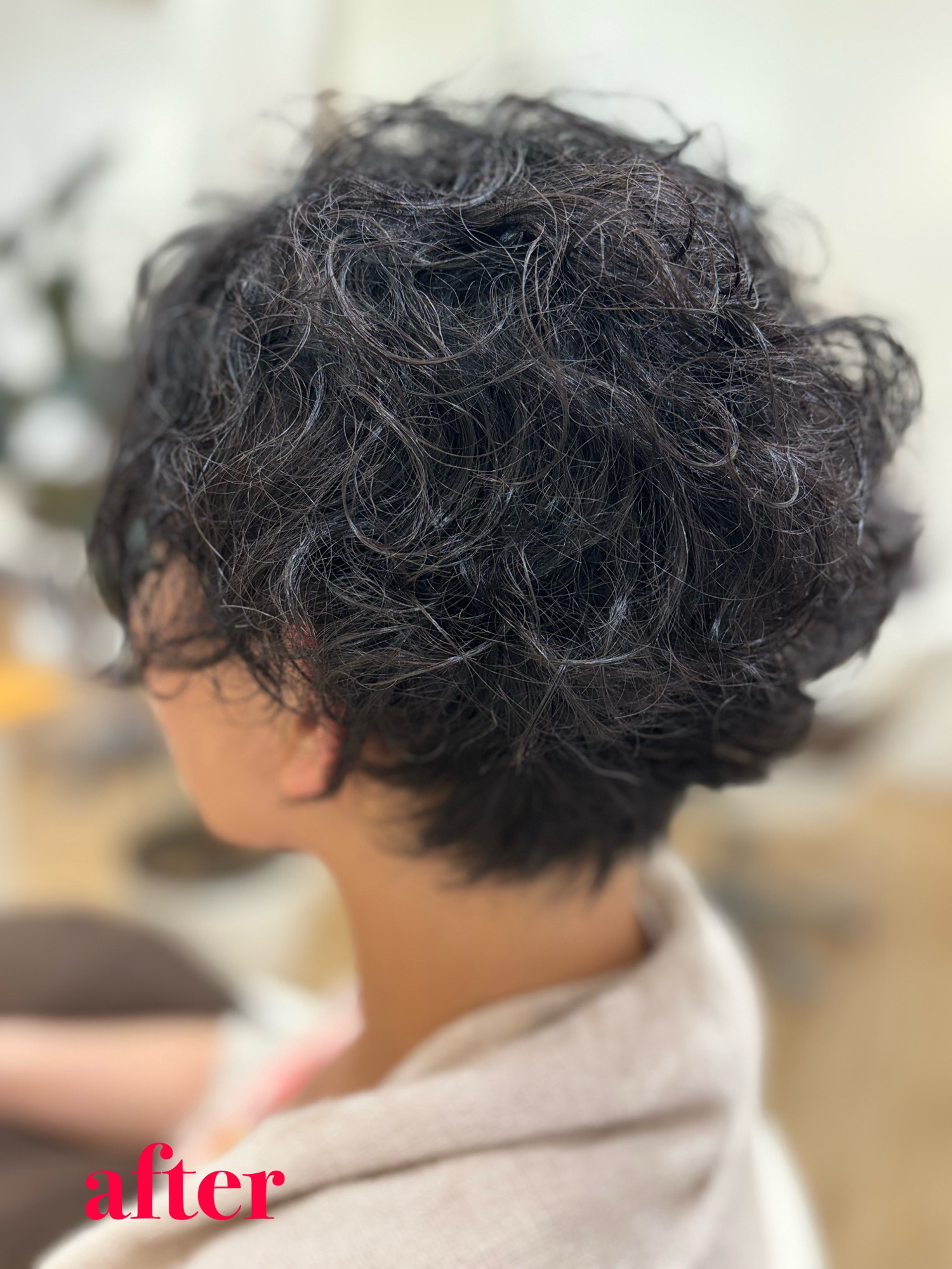 バッサリカットから2ヶ月経過後。癖毛を活かしてパーマ風に仕上げた、動きのあるショートスタイルのバックビュー