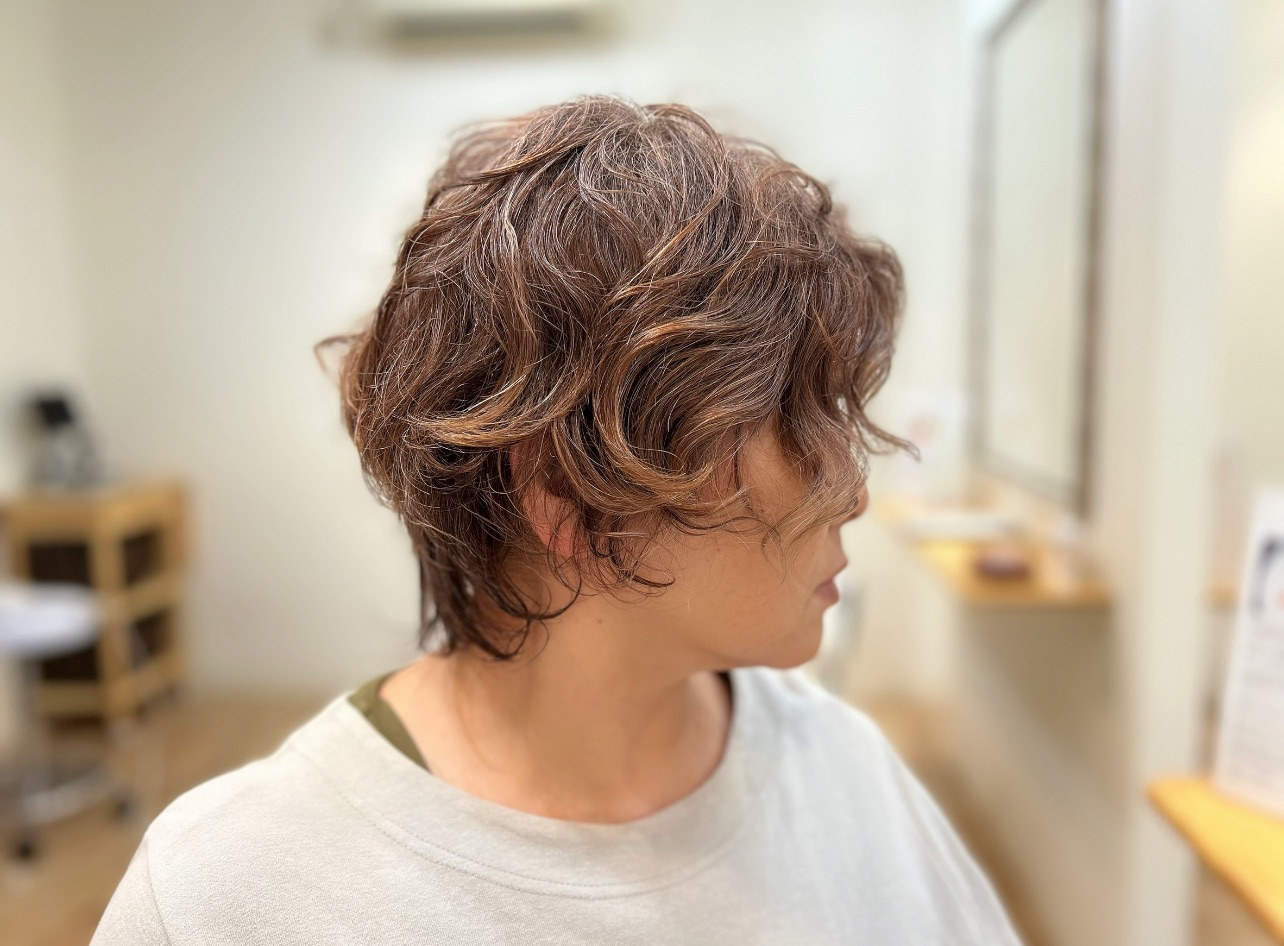 首元がすっきり見え、頬にかかるカールで小顔効果も期待できるウルフパーマのサイドシルエット